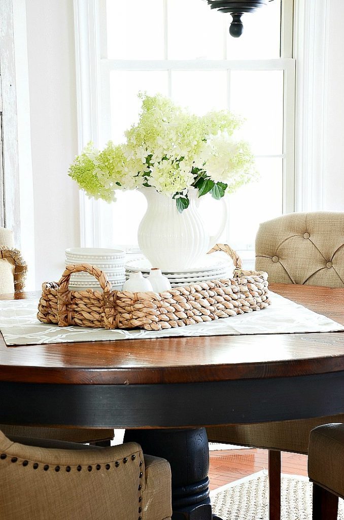 kitchen table with vignette of plates and urn of hydrangeas