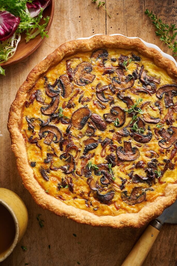 bacon onion mushroom quiche in a white pie pa