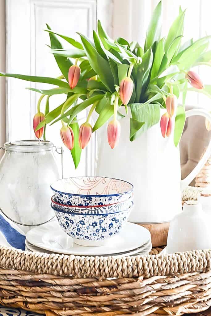 DECORATING WITH RISERS- wood round riser with a pitcher of tulips on top of it