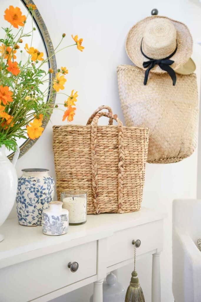 straw tote bags and a straw hat used as decor in the foyer