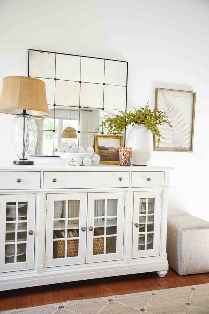 large mirror above a white buffet