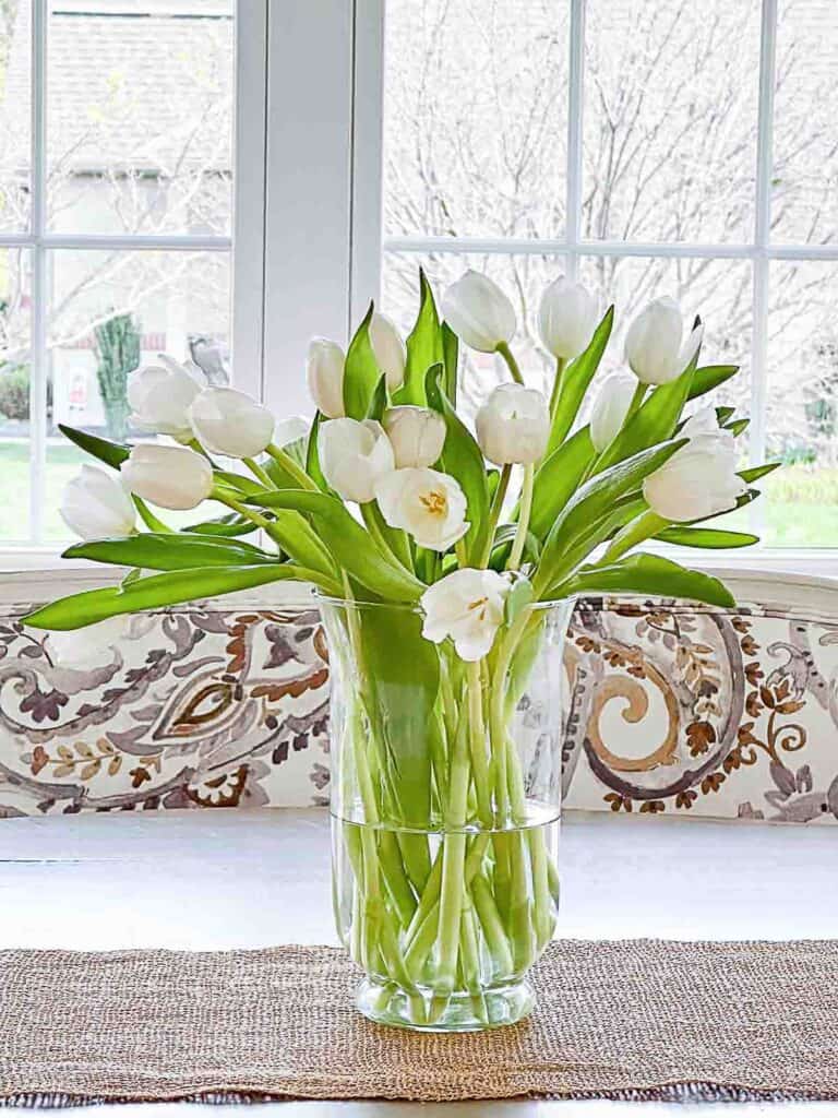 vase of tulips on a dining room table