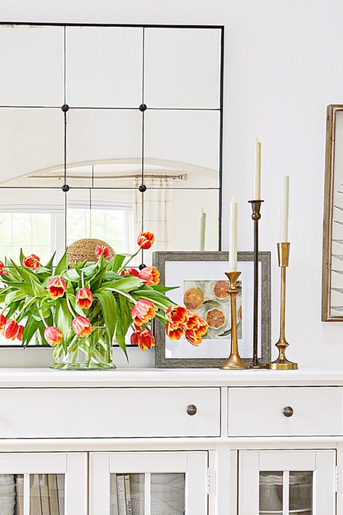 tulips and candlesticks on a white buffet
